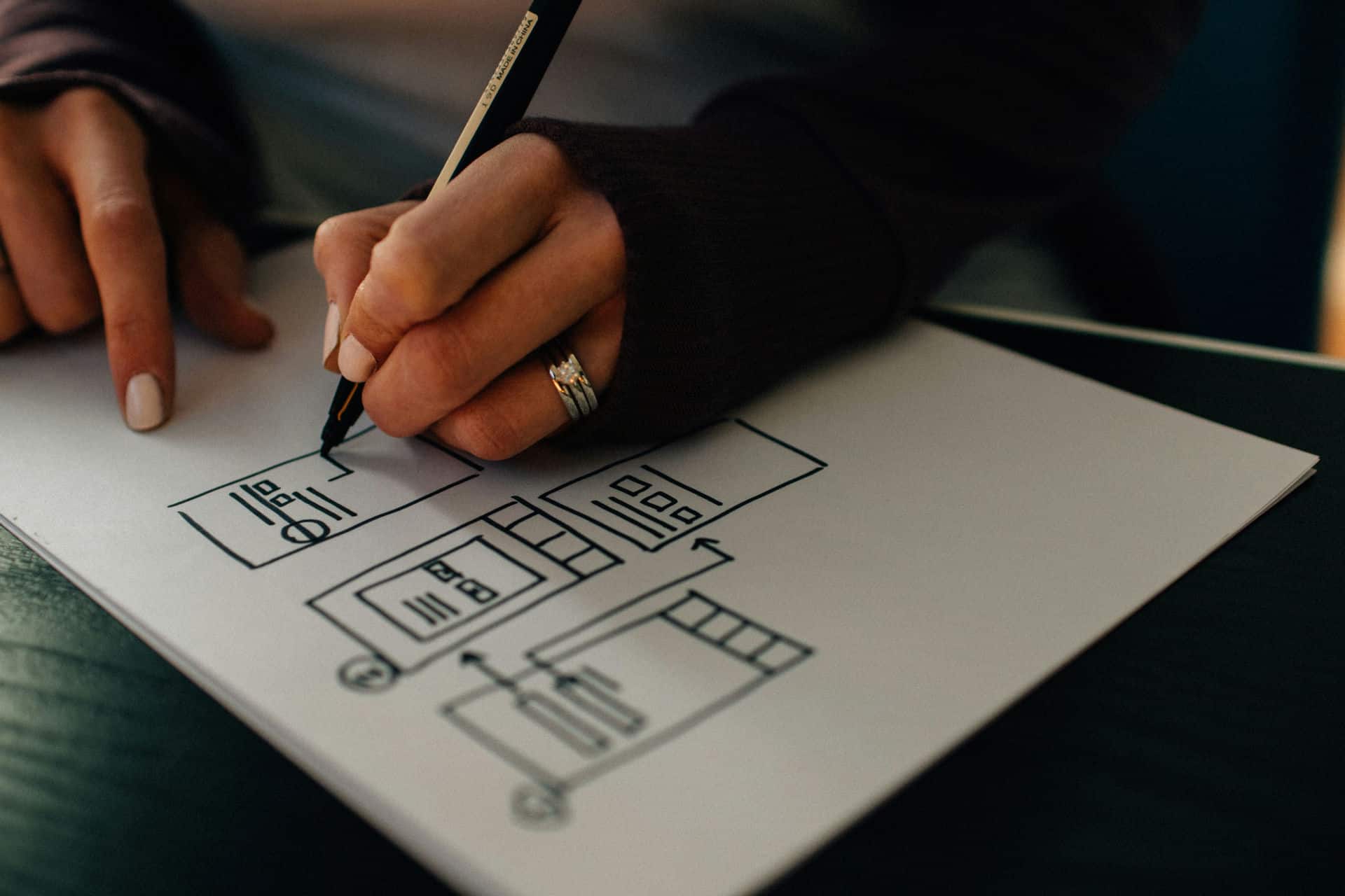A designer sketching a website wireframe by hand